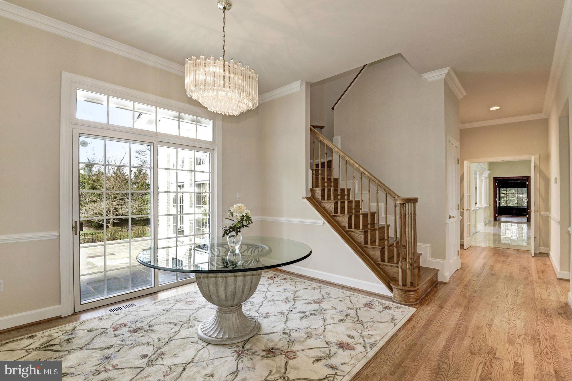 11112 Potomac View Drive Potomac, MD 20854 - Photo 10 of 30 a dining room with wooden floor a chandelier a rug a potted plant and windows