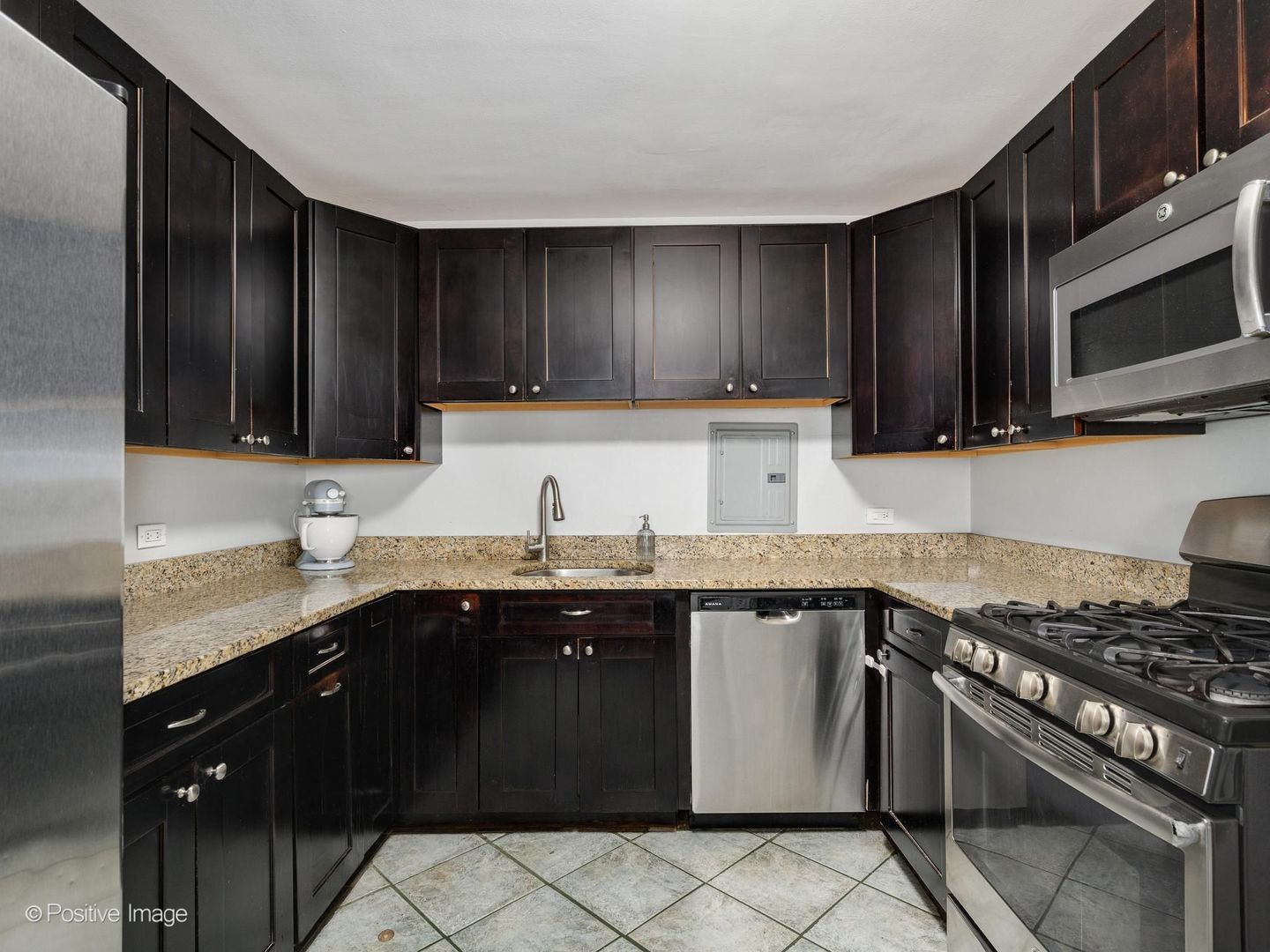 5801 North Sheridan Road, Unit 16B Chicago, IL 60660 - Photo 11 of 23 a kitchen with stainless steel appliances a sink dishwasher a stove top oven a refrigerator and cabinets