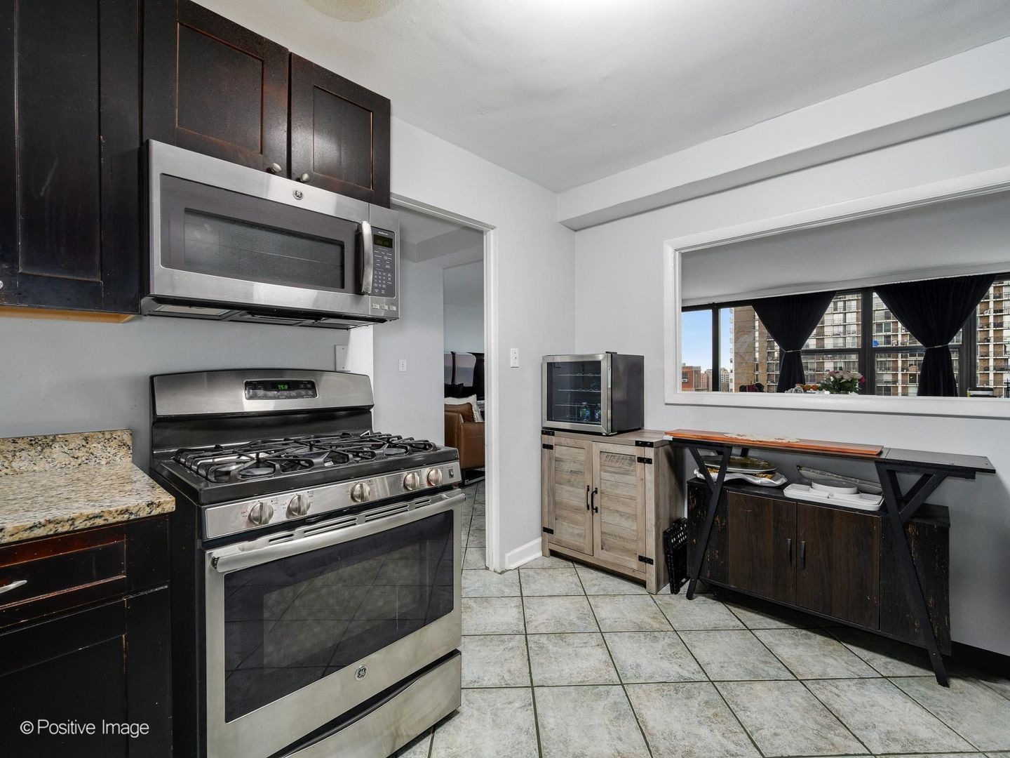 5801 North Sheridan Road, Unit 16B Chicago, IL 60660 - Photo 12 of 23 a kitchen with stainless steel appliances granite countertop a stove microwave and sink