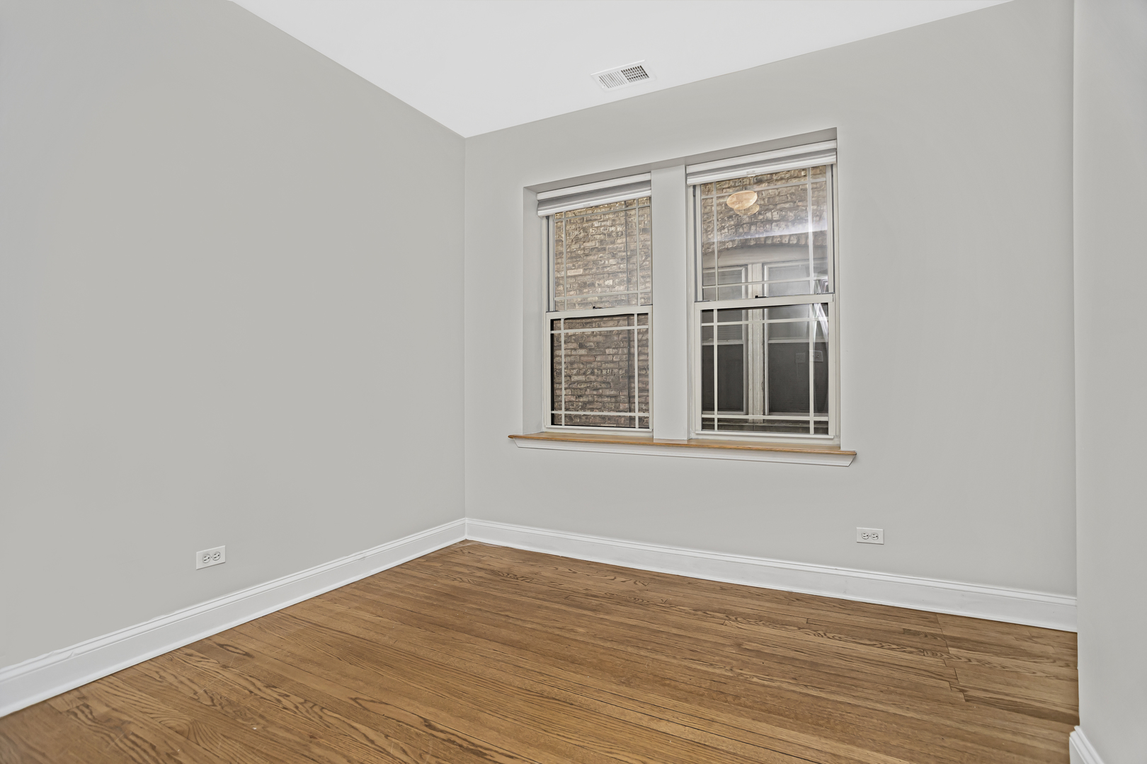 1210 West Roscoe Street, Unit 1 Chicago, IL 60657 - Photo 11 of 20 a view of empty room with wooden floor and fan
