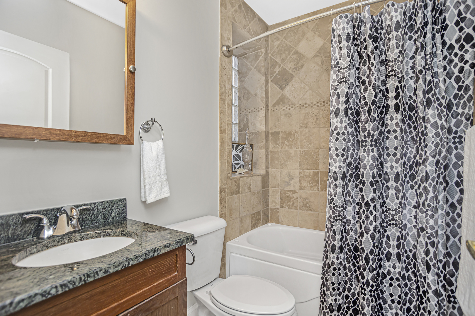 1210 West Roscoe Street, Unit 1 Chicago, IL 60657 - Photo 13 of 20 a bathroom with a granite countertop sink toilet and shower