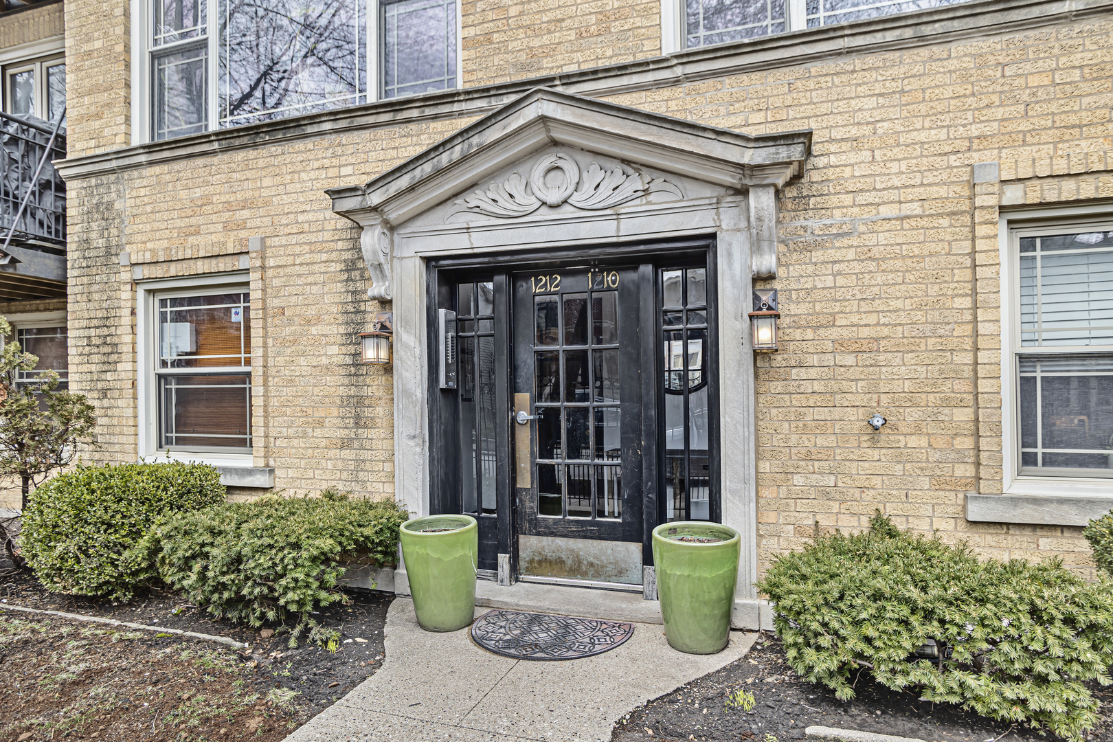 1210 West Roscoe Street, Unit 1 Chicago, IL 60657 - Photo 2 of 20 a view of a brick house with potted plants