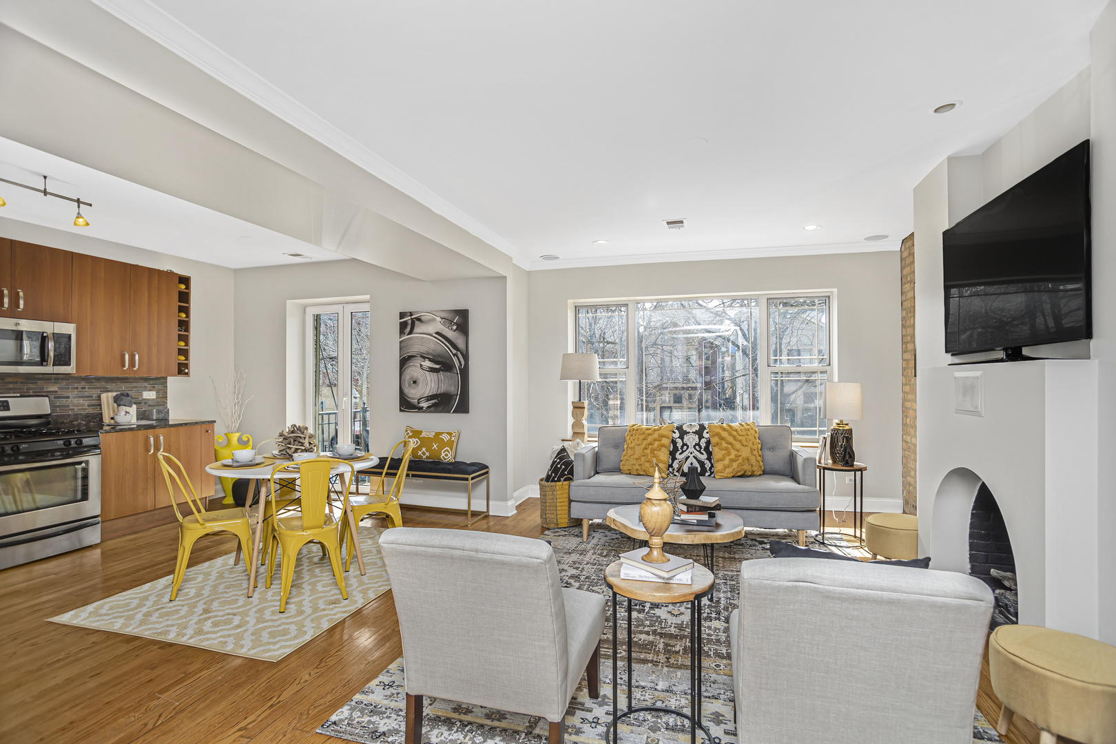 1210 West Roscoe Street, Unit 1 Chicago, IL 60657 - Photo 3 of 20 a living room with fireplace furniture and a flat screen tv