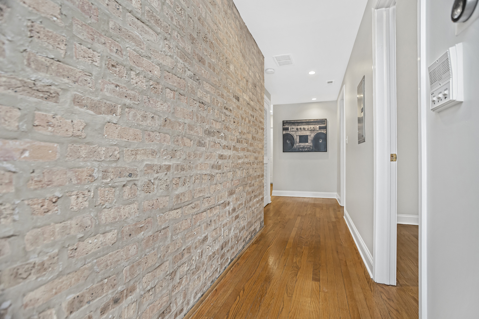 1210 West Roscoe Street, Unit 1 Chicago, IL 60657 - Photo 10 of 20 a view of a hallway with wooden floor