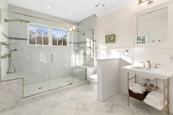 a bathroom with a shower sink and mirror