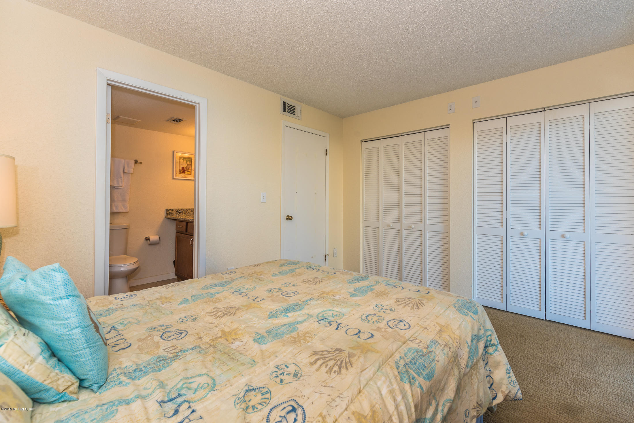 890 A1A Beach Boulevard, Unit 50 St. Augustine, FL 32080 - Photo 17 of 71 a bedroom with a bed and a mirror