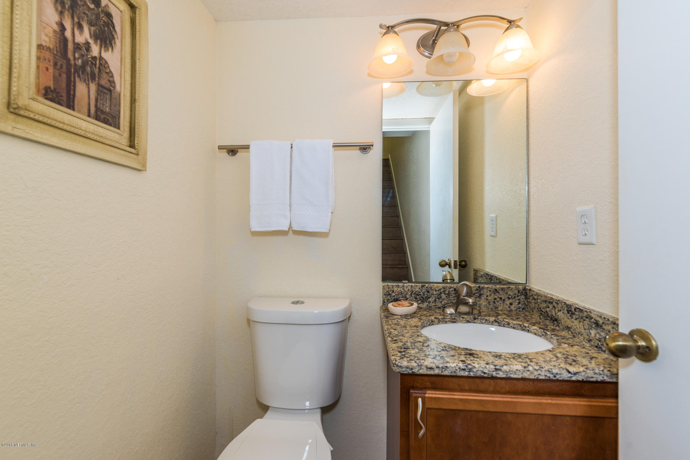 890 A1A Beach Boulevard, Unit 50 St. Augustine, FL 32080 - Photo 40 of 71 a bathroom with a granite countertop toilet sink and mirror