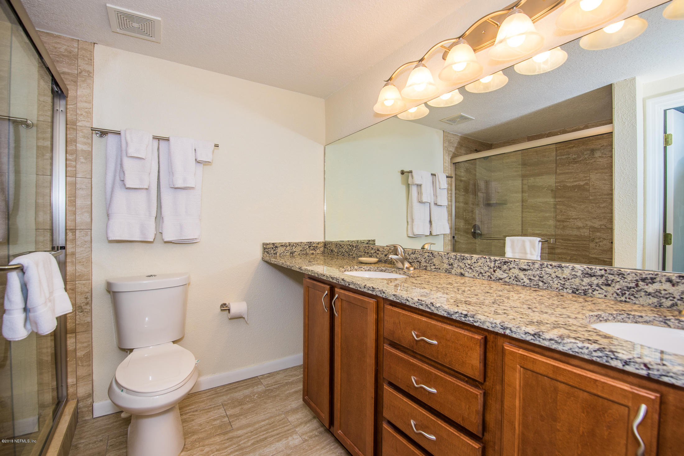 890 A1A Beach Boulevard, Unit 50 St. Augustine, FL 32080 - Photo 47 of 71 a bathroom with a granite countertop toilet sink and mirror