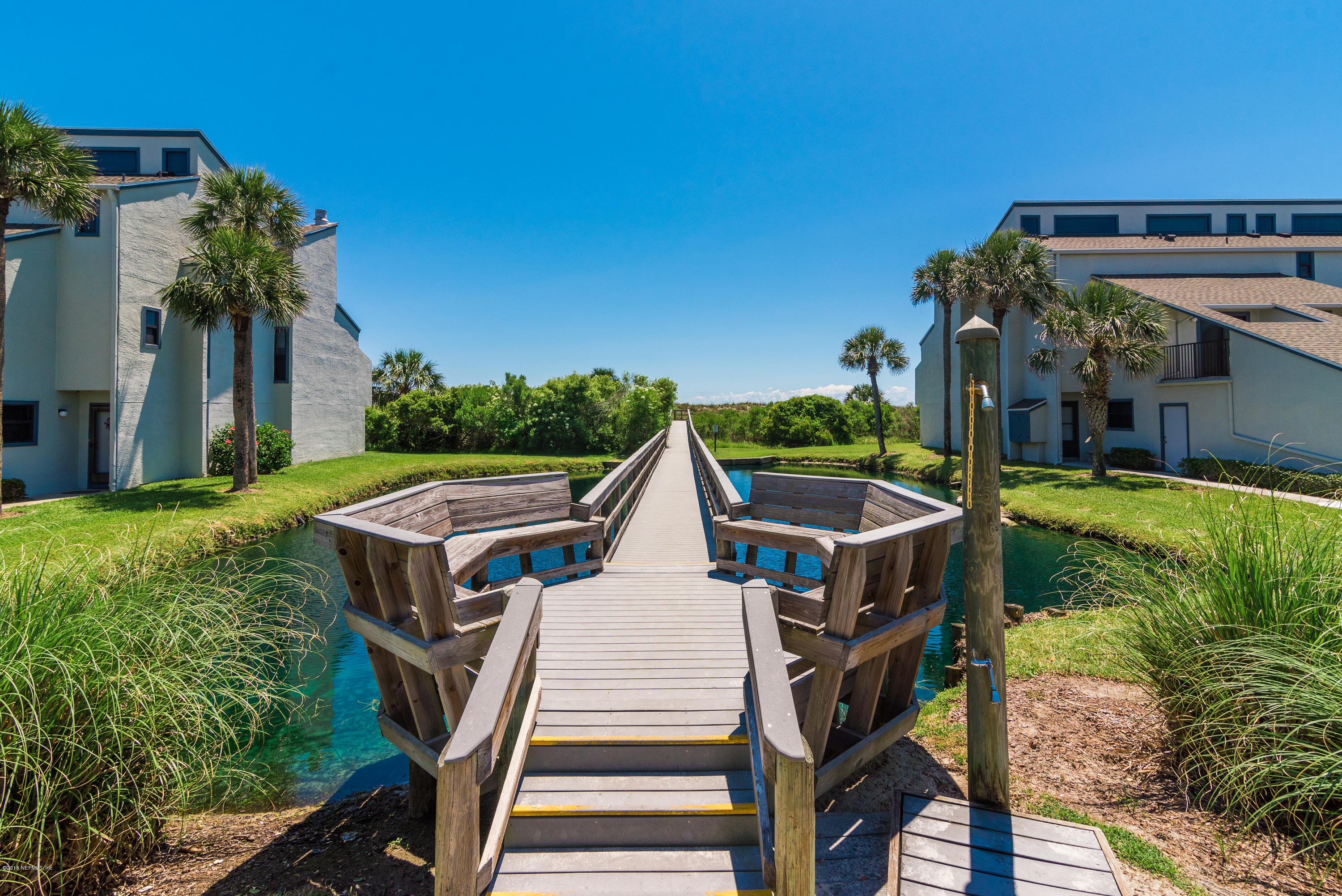 890 A1A Beach Boulevard, Unit 50 St. Augustine, FL 32080 - Photo 58 of 71 a view of a patio with table and chairs with wooden floor and fence