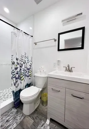 a bathroom with a toilet sink and a mirror