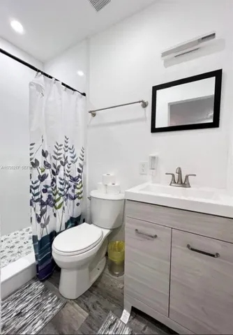 a bathroom with a toilet sink and a mirror