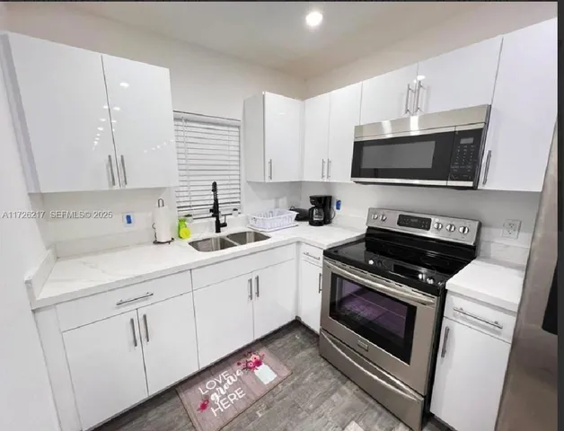 a kitchen with cabinets appliances and a sink