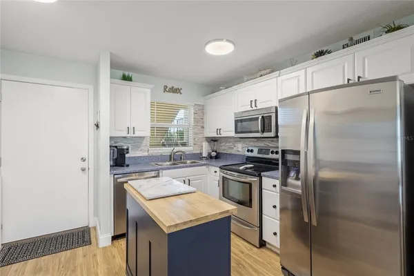 a kitchen with a refrigerator stove microwave and sink