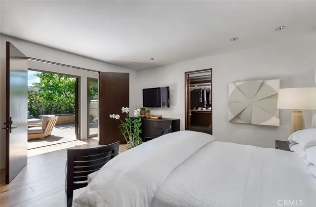 a bedroom with a large bed and a flat tv screen