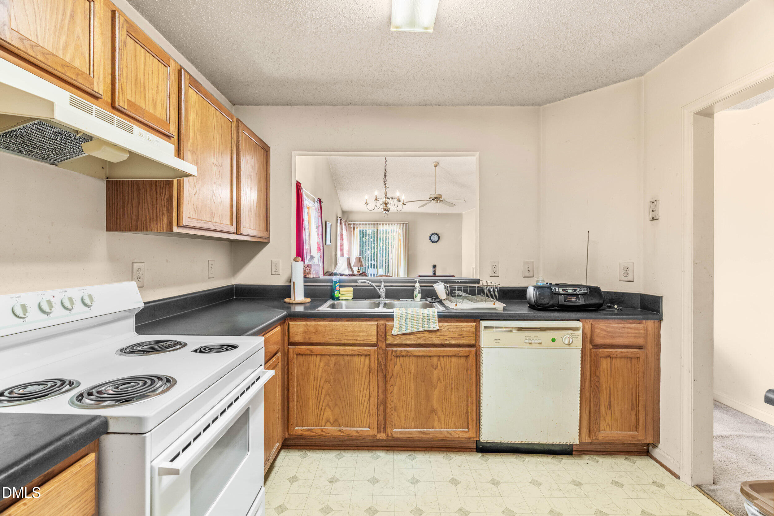6010 Newhall Road Durham, NC 27713 - Photo 3 of 21 a kitchen with a sink stove and cabinets