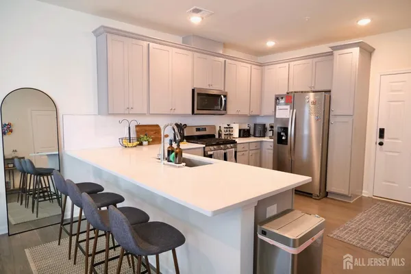 a kitchen with granite countertop a refrigerator a stove a sink a dining table and chairs