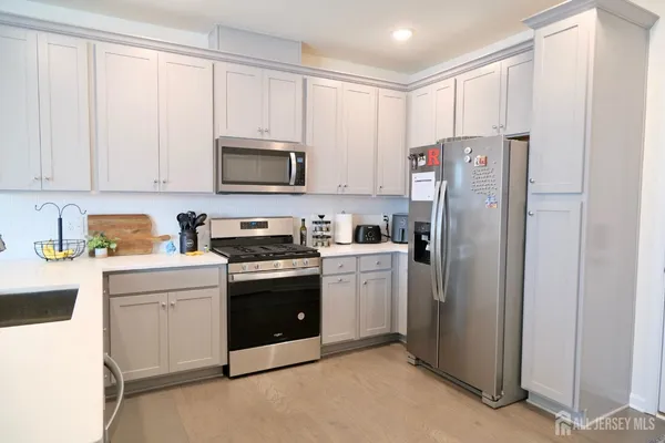 a kitchen with a refrigerator sink and cabinets