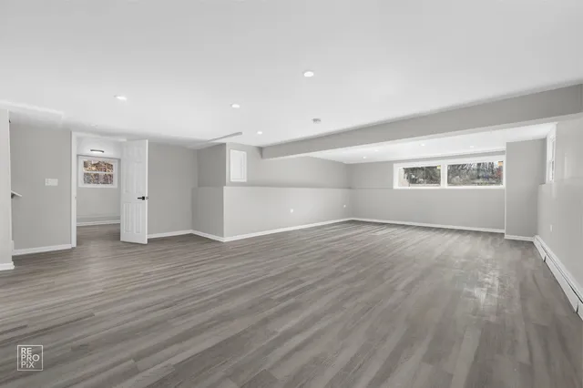 an empty room with wooden floor and window