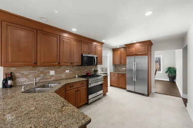 a kitchen with stainless steel appliances granite countertop a refrigerator and a sink