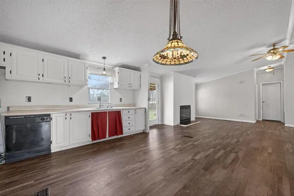 a kitchen with stainless steel appliances a stove a sink cabinets and wooden floor