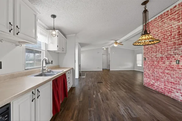 a kitchen with granite countertop a sink appliances and cabinets