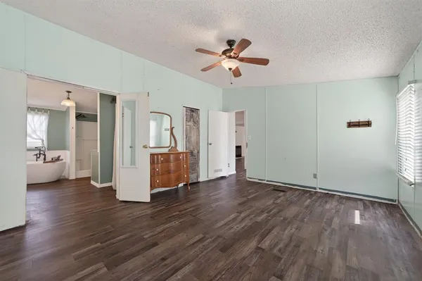 a view of a livingroom with wooden floor and a ceiling fan