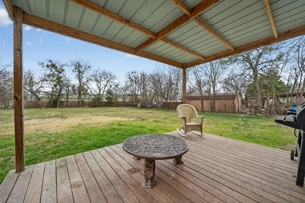 a view of a chair and table on the wooden deck