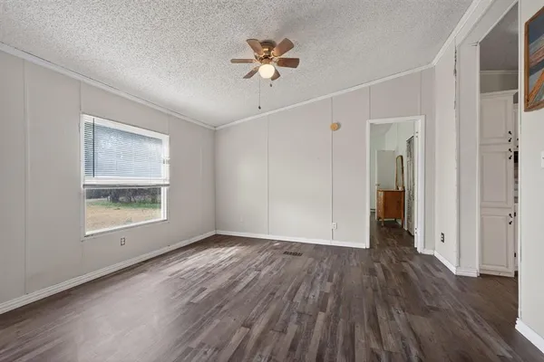 a view of an empty room with a window and wooden floor