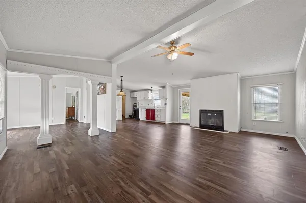a view of empty room with fireplace and wooden floor