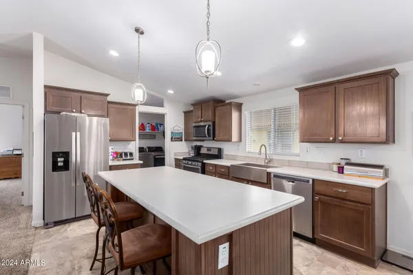 a kitchen with stainless steel appliances a kitchen island a sink cabinets and refrigerator