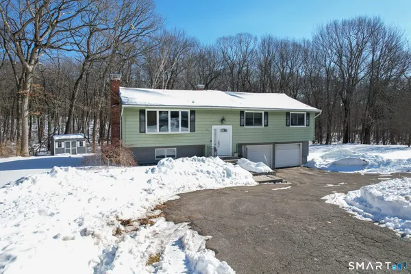 a view of a house with a yard covered in snow