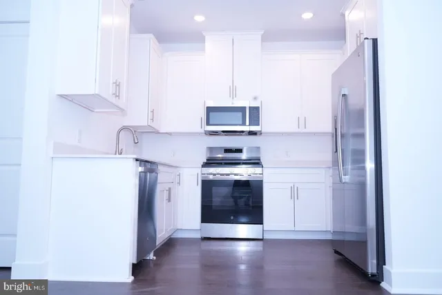 a kitchen with stainless steel appliances granite countertop a stove a refrigerator and a microwave