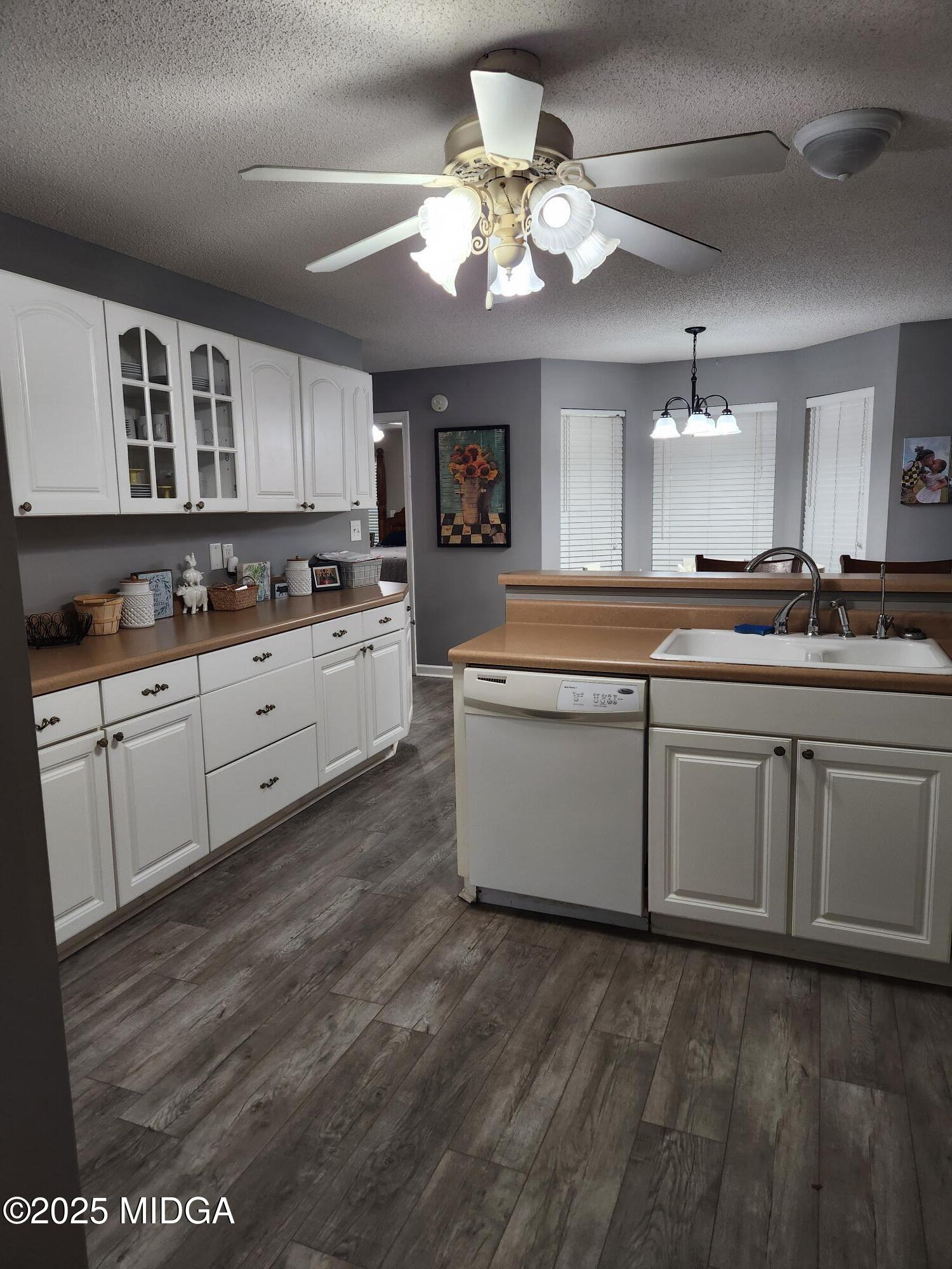 254 Crestview Lane Gray, GA 31032 - Photo 6 of 15 a large kitchen with stainless steel appliances granite countertop a sink dishwasher a stove and white cabinets with wooden floor