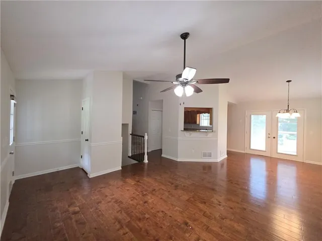 a view of a livingroom with a chandelier fireplace and wooden floor