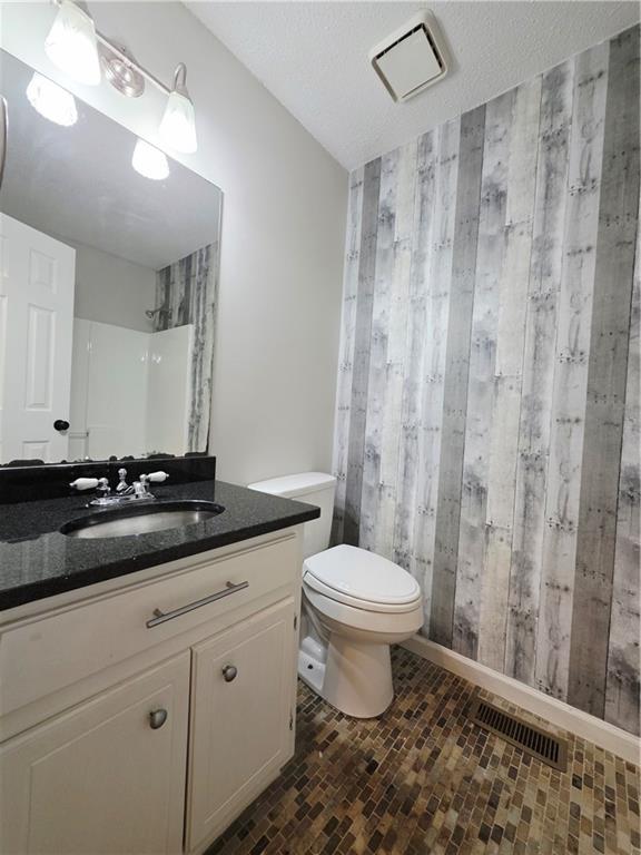 570 Remington Lane Acworth, GA 30101 - Photo 8 of 20 a bathroom with a granite countertop sink a toilet a mirror and shower curtain