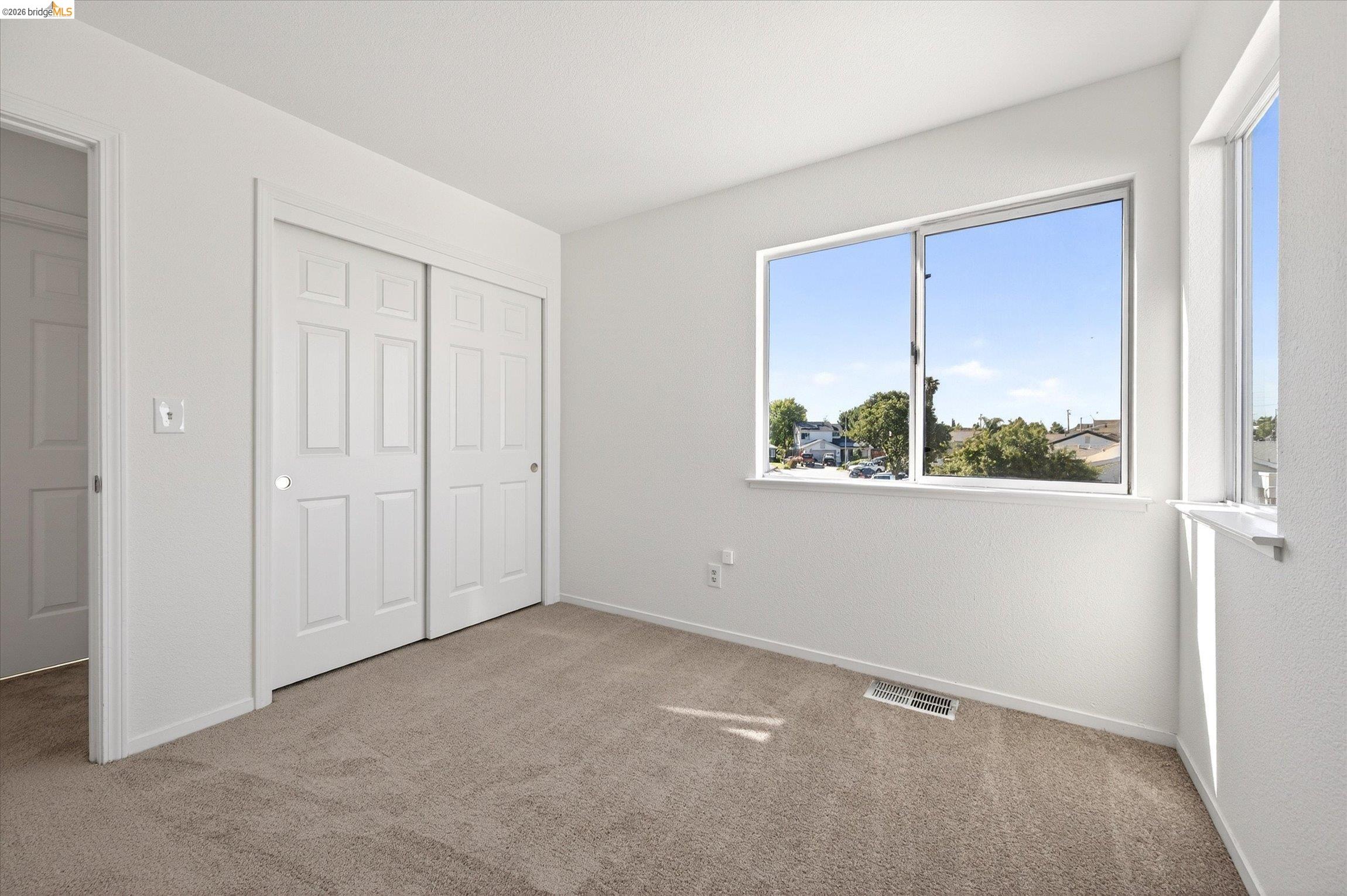 1120 Deerpark Road Oakley, CA 94561 - Photo 24 of 30 Light-filled room featuring neutral carpet flooring, a spacious double-door closet with paneled doors, and multiple windows providing ample natural light