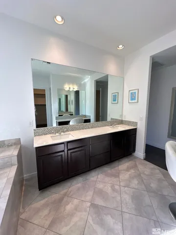 a large bathroom with a granite countertop sink and a large mirror