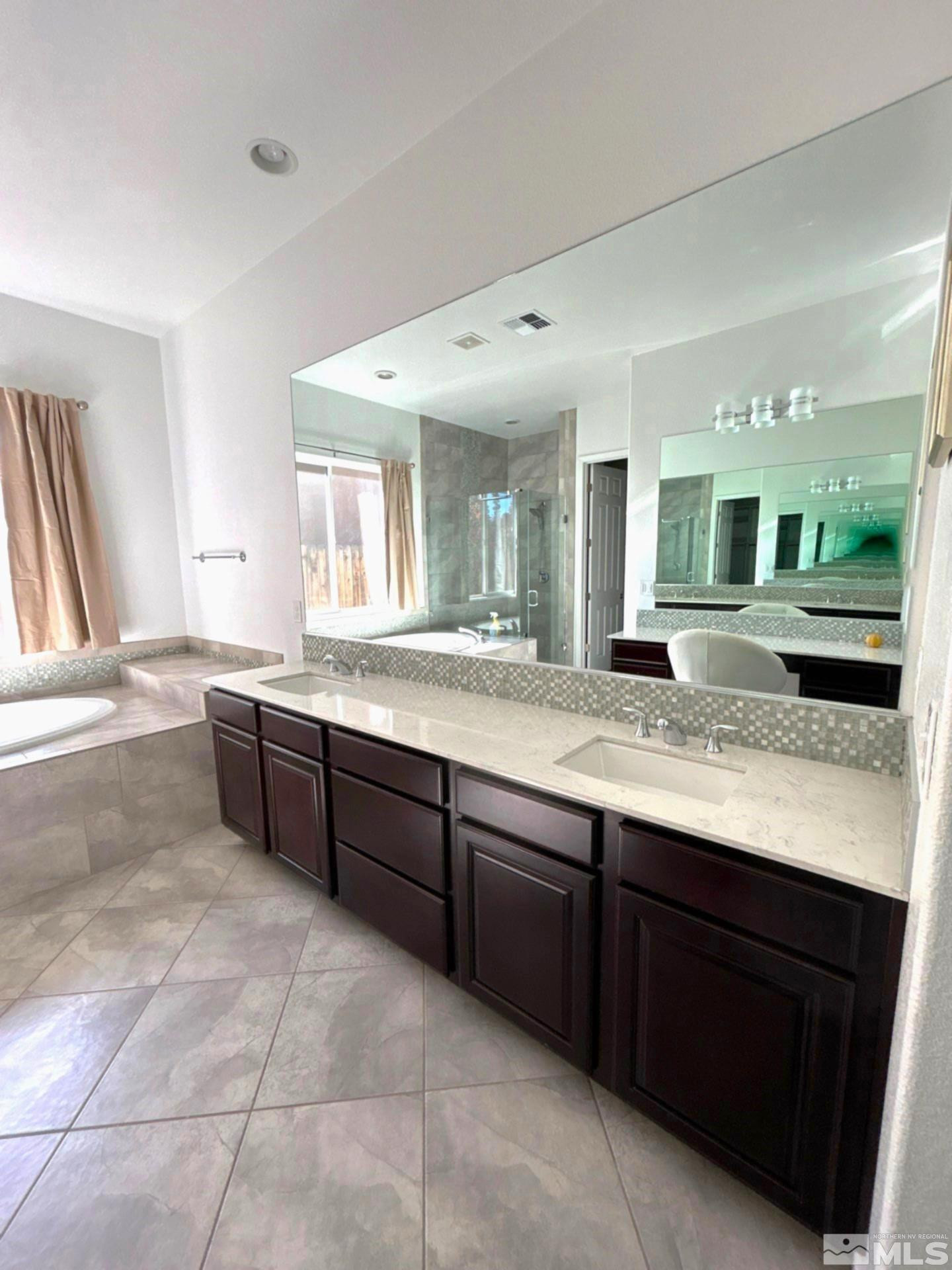 2070 Blue Boy Lane Reno, NV 89521 - Photo 18 of 31 a large bathroom with a granite countertop sink and a large mirror