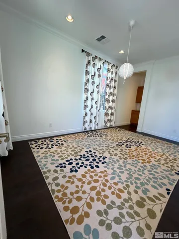 a view of a room with wooden floor and a window