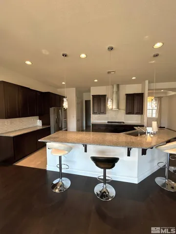 a kitchen with a table chairs refrigerator and a stove