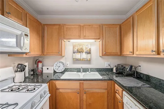 a kitchen with stainless steel appliances granite countertop a sink stove and cabinets