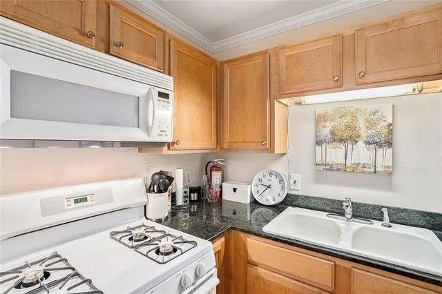 a kitchen with a sink a stove and cabinets