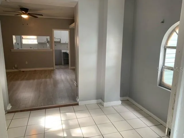 a view of a refrigerator in kitchen and an empty room