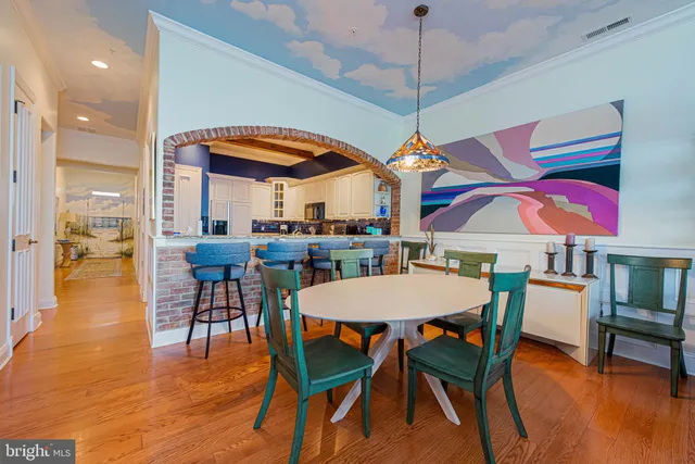 a dining room with wooden floor table and chairs