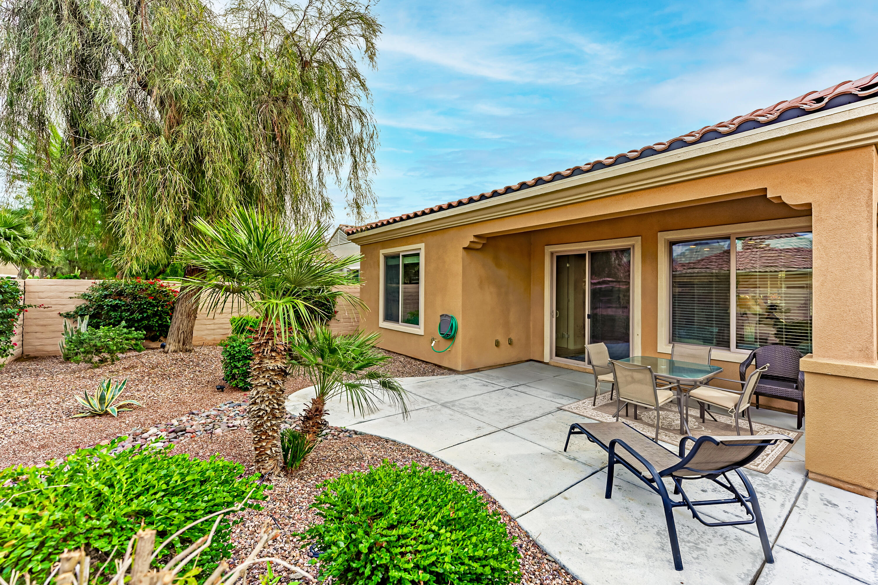a backyard of a house with outdoor seating and barbeque oven