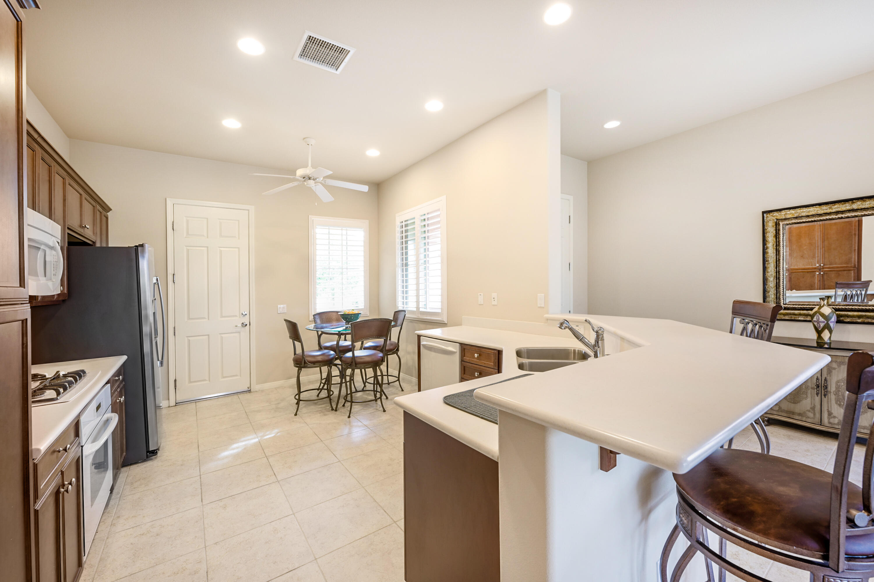 81674 Avenida Celaya Indio, CA 92203 - Photo 11 of 43 a living room with stainless steel appliances furniture a dining table and a refrigerator