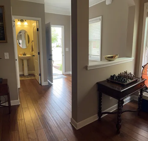 a view of a hallway with wooden floor and a sink