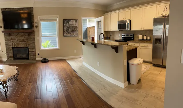 a kitchen with stainless steel appliances a stove top oven a sink a refrigerator a window and cabinets