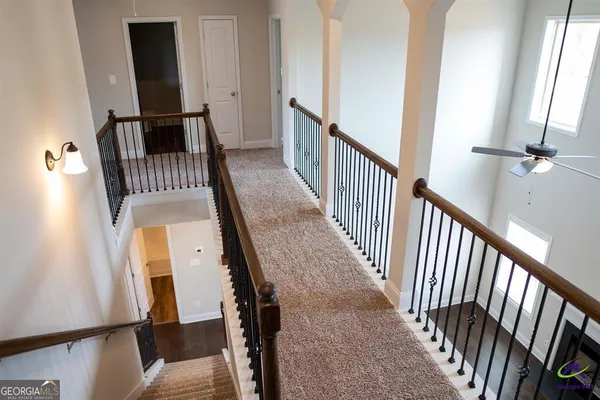 a view of a hallway with wooden floor and staircase