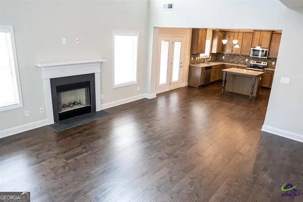 a view of a living room and kitchen with a fireplace